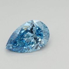 a pear shaped blue diamond on a white surface