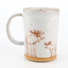 a coffee mug with an image of two moose on it's side and the bottom is brown