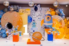 an image of a birthday party with balloons and space themed decorations on the wall behind it