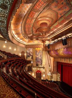 an auditorium with red seats and ornate ceiling