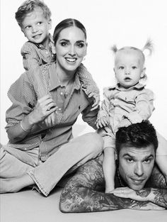 a woman and two children are sitting on the floor with their arms around each other