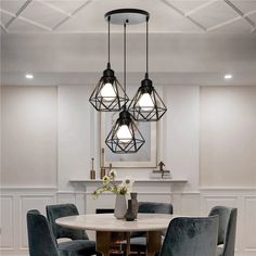 a dining room table with four chairs and a chandelier hanging over the top