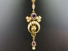 Fabulous Indian reproduction of English Edwardian jewellery Circa: 1900s. This wonderful unique piece of jewellery is a very rare find. Displays Art Deco influences which was typical of the era. Featuring 24 white seed Pearls. For added colour the piece has two purple Amethysts. Amethyst is the birthstone for February and the name is from the Greek word meaning 'Not Drunken'. According to mythology it inspires fairness and a sense of duty. The pendant is presented in excellent condition for a pi