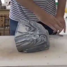 a person is making something out of marble