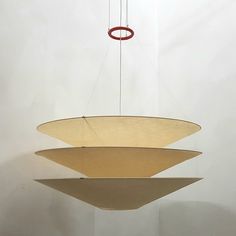 a light fixture hanging from the ceiling in a room with white walls and flooring