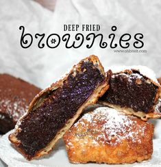 deep fried brownies on a white plate with powdered sugar and chocolate toppings