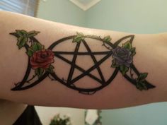 a tattoo with roses and an inverted pentagramil on the arm is shown in this image