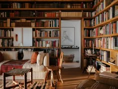 a living room filled with furniture and lots of bookshelves full of different types of books