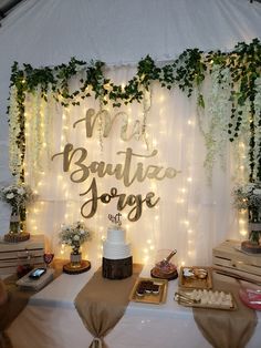 a table topped with cake and desserts under a white canopy covered in fairy lights