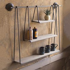 three shelves with pots and cups on them in front of a wall mounted pot rack