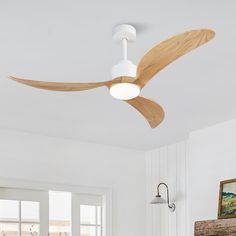 a white ceiling fan with wooden blades in a living room