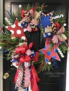 a patriotic wreath with red, white and blue stars on the front door for memorial day