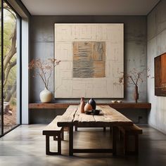 a table with two vases sitting on top of it next to a wall mounted painting