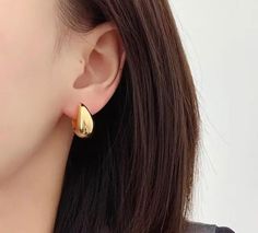 Add a touch of sophistication to your look with our stunning water drop hoop earrings in 18k gold. These elegant earrings feature a delicate water drop shape, crafted from lustrous 18k gold for a luxurious finish. The water drop shape is both timeless and contemporary, making it a versatile accessory that works well with any outfit. The 18k gold is carefully polished to create a sleek and shiny surface, while the lightweight design ensures maximum comfort for extended wear. Whether you're dressi Everyday Teardrop Huggie Earrings, Tarnish Resistant Teardrop Hoop Earrings, Gold Teardrop Hoop Earrings Tarnish Resistant, Minimalist Gold Plated Teardrop Earrings, Elegant Gold Teardrop Huggie Earrings, Classic Teardrop Single Hoop Earring, Elegant Tarnish Resistant Drop Earrings For Formal Occasions, Elegant Pear-shaped Yellow Gold Hoop Earrings, Elegant Yellow Gold Pear-shaped Hoop Earrings