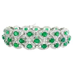 This stunning link bracelet features an intricate criss-cross pattern, showcasing 405 white round diamonds totaling 3.69 carats. At the heart of this exquisite design sit 45 oval-cut emeralds, collectively weighing 14.22 carats, adding a touch of vibrant green elegance. Crafted in 14k white gold and weighing 36.85 grams, this bracelet combines luxury and sophistication, making it an ideal accessory for any party or special event. The meticulous arrangement of diamonds and emeralds creates a captivating visual effect, ensuring you stand out in any crowd. Its elegant design and exceptional craftsmanship make this bracelet a versatile piece that can elevate your evening attire or add a touch of glamour to a formal ensemble. With its perfect blend of sparkle and color, this criss-cross pattern Luxury Green Bracelet With Intricate Design, Emerald Bracelets, Modern Bracelets, Emerald Bracelet, Sapphire Bracelet, Cross Patterns, Emerald Stone, Vibrant Green, Emerald Cut Diamonds