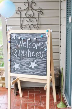 a welcome sign on the front porch with balloons and streamers in the air next to it