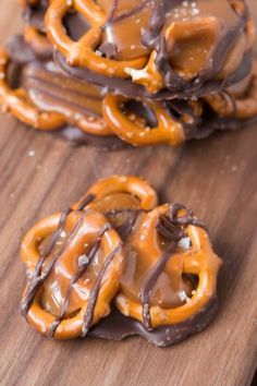 some pretzels are sitting on top of a wooden table with chocolate drizzled on them