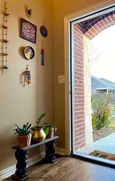 an open door leading to a patio with jewelry hanging on the wall