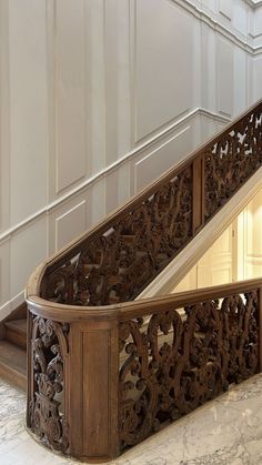 an ornate wooden staircase with marble flooring