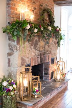 the fireplace is decorated with greenery and candles