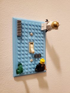 a lego light switch plate is shown with some toys on it's side,