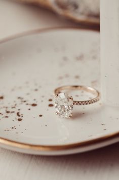 a close up of a plate with a ring on it and a cup in the background