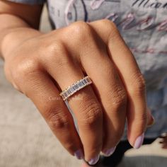 a woman's hand with a diamond ring on her left thumb and the middle finger