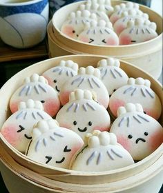 two bowls filled with decorated cookies on top of a table