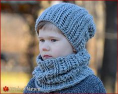 a young boy wearing a blue knitted hat and scarf with a red frame around his neck