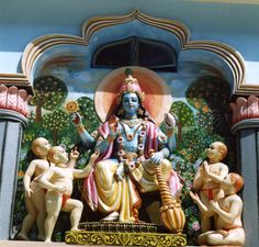 a statue of the hindu god ganesh in front of a blue and white building