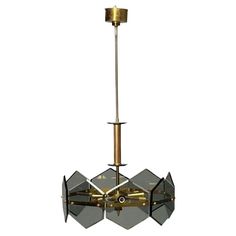 a brass chandelier with glass panels and two lights hanging from the ceiling, on an isolated white background