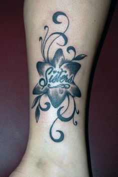 a woman's foot with a tattoo that says sister on the bottom and an image of a flower in the middle