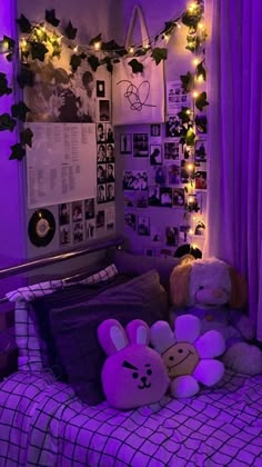 a bedroom with purple lights and stuffed animals on the bed in front of it,