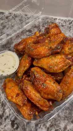 chicken wings in a plastic container with ranch dressing