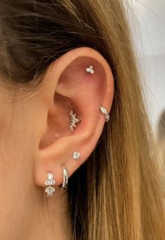 a woman wearing three different ear piercings