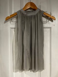 a dress hanging on a hanger in front of a door with a wooden handle