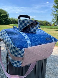 a blue and white checkered bag sitting on top of a trash can with a pink leash