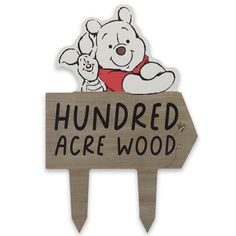 a wooden sign with a winnie the pooh on it that says hundred acre wood