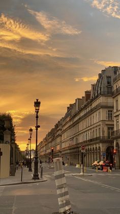 an empty city street at sunset with buildings in the background