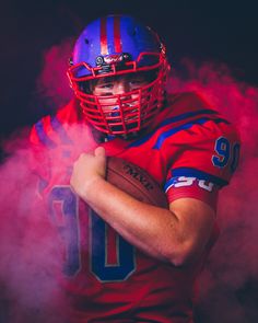 a football player wearing a red and blue uniform with his arms crossed in front of him