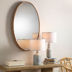 a table with two lamps and a mirror on it