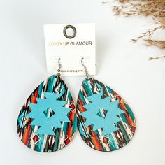 Wooden Serape teardrop earring with aztec print in Blue multicolor, pitcured with pampas grass on a white background. Serape Earrings, Giddy Up Glamour, Jewelry Wire, Handmade Jewelry Diy, Metal Earrings, Aztec Print, Teardrop Earrings, Wire Jewelry, Sale Items