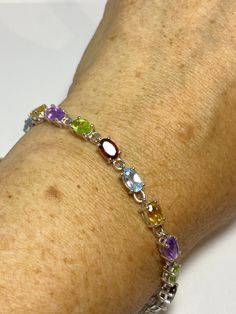 This genuine bright red garnet, citrine, blue topaz, amethysts, and peridot bracelet is very lively and bright. The stones are deep colors natural stones The sterling silver is plated with rhodium to protect the bracelet from tarnish 7.5 in Our jeweler can shorten it for $20 All jewelry is shipped free in the US in a nice gift box. Check out our over a THOUSAND great reviews Engraving is $4 per letter and is not always perfect depending on the piece. It can take a few days if the jeweler is busy Sterling Silver Multicolor Stone Bracelets, Multicolor Sterling Silver Bracelets With Stones, Oval Sterling Silver Bracelets With Multi-stone, Multicolor Gemstone Sterling Silver Bracelets, Sterling Silver Multicolor Gemstone Bracelet, Multicolor Sterling Silver Bracelet With Natural Stones As Gift, Multicolor Sterling Silver Bracelet With Natural Stones, Sterling Silver Multicolor Gemstone Bracelets, Multicolor Multi-stone Sterling Silver Bracelet As A Gift