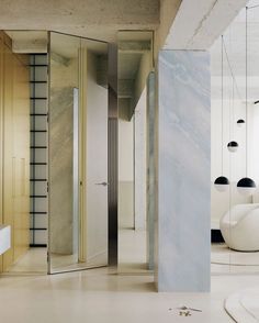 the interior of a modern bathroom with marble walls and floor, along with large mirrors