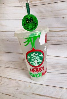 a starbucks cup with a green smiley face on the top and merry nighman sticker