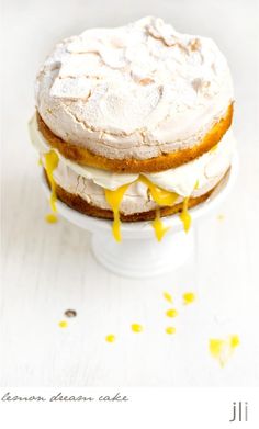 a cake with frosting and yellow sprinkles sitting on top of a white plate