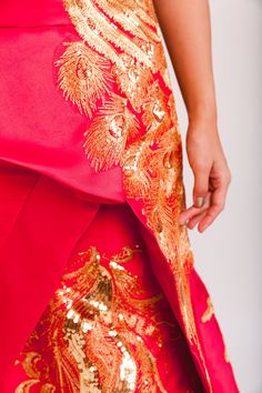 A strapless gown decorated with a beautiful peacock embroidery perfect for your Chinese wedding. The corset back allows you to easily adjust the size and comfort of the dress. It's the perfect dress for you to embrace your culture in for any special occasion. Check out additional dresses at www.eastmeetsdress.com. The Details: - Red polyester fabric with gold peacock embroidery - Strapless, mermaid silhouette - Floor length with a moderate train - Corset back - Fully lined Sizing: - This dress c Festive Strapless Wedding Dresses, Peacock Wedding Dress, Peacock Wedding Dresses, Red Chinese Wedding Dress, Chinese Dress Qipao, Wedding Dresses Xl, Wedding Dress Red, Peacock Embroidery, Modern Cheongsam Dress