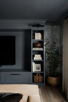 a living room filled with furniture and a flat screen tv on top of a book shelf