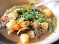 a white bowl filled with stew and vegetables