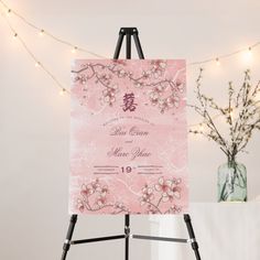 an easel with a pink wedding card on it